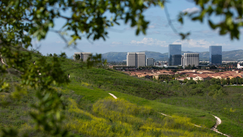 Grassy hills in Irvine with buildings in the background.