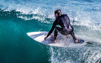 A man surfs on a wave. Huntington beach is known for its surfing.