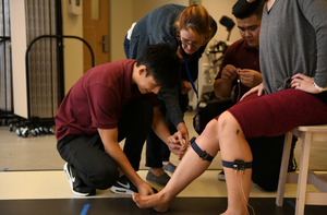 Students assist a patient in the Gait Rehabilitation Lab.