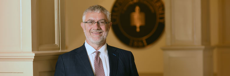 President Struppa posing in front of seal