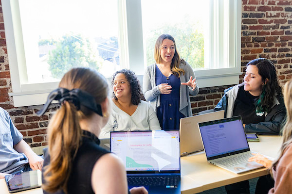 Faculty members use laptops and meet in classroom