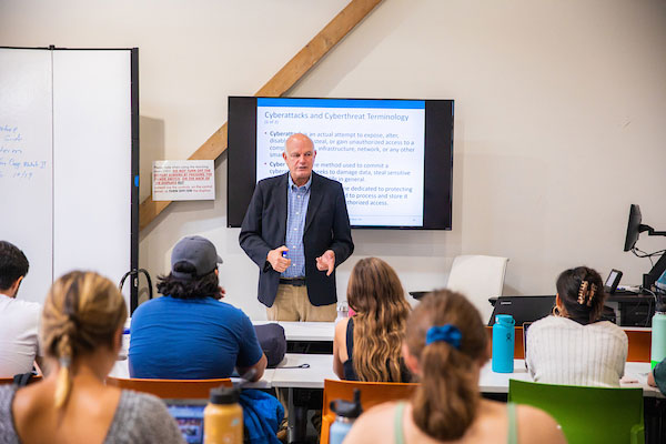 Faculty teaches in front of classroom of students