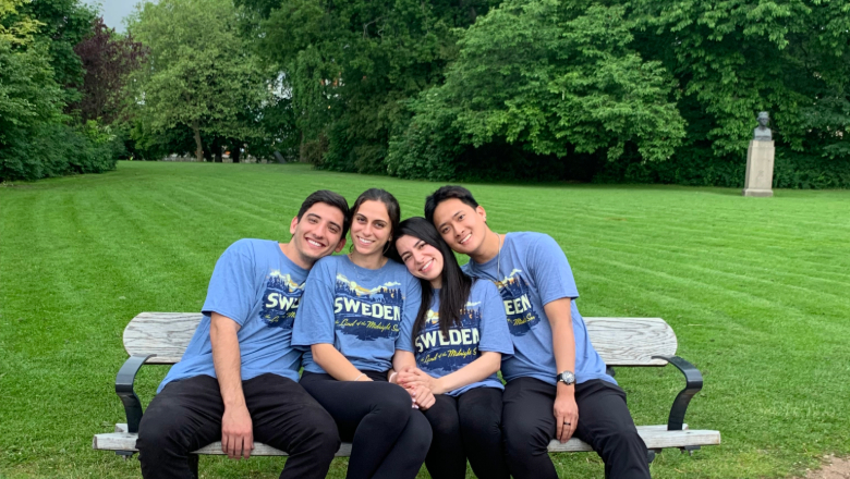 Study abroad students sit on bench wearing matching tshirts