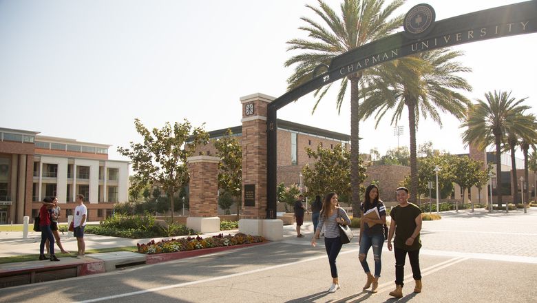 Students walking on the Chapman campus near Schmid gate