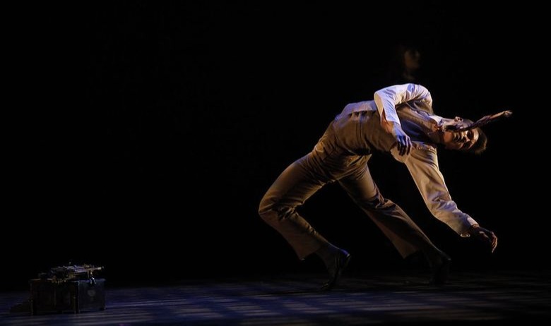 A dancer on a dark stage