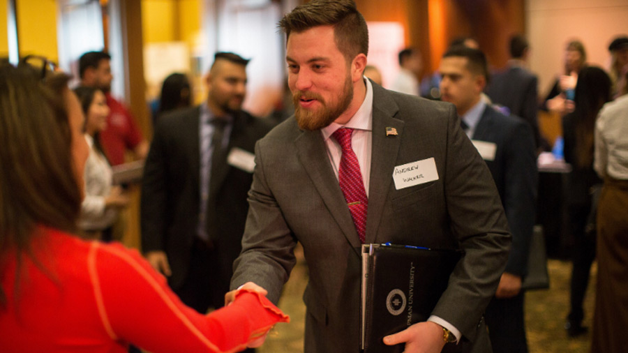 Alum shaking hands with employer at career fair