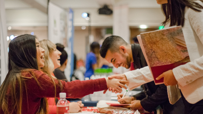 candidate shaking hands with employer at career fair