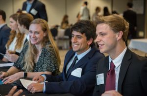 Students wearing business attire sit in a conference.