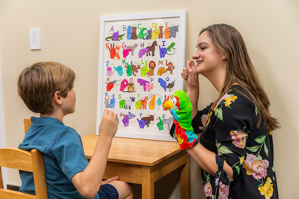 Dr. Lee teaching sign language to a child.