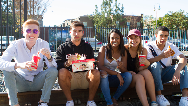 Chapman Student outdoors easting together