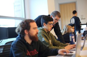 Screenwriting students working on laptops in a classroom