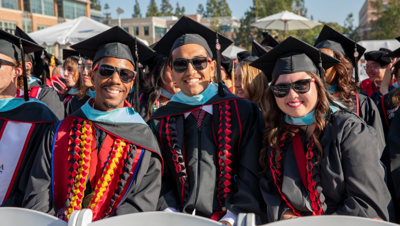 Attallah College graduates in cap and gown on commencement day