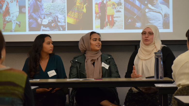 Workshop presenters sitting at a table in front a slideshow at the 2018 Ethnic Studies Summit