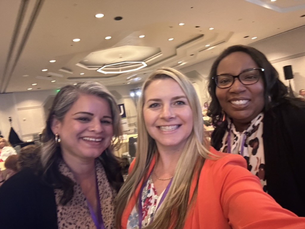 three women at a conference 