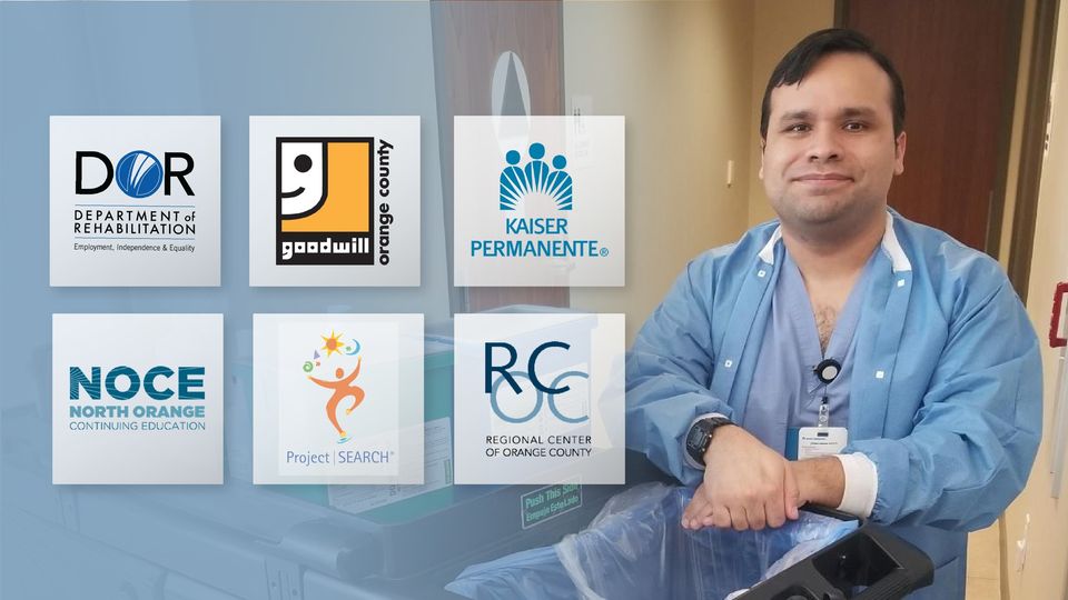 Alex stands smiling with his hands folded and placed on top of a medical cart. He is wearing blue medical scrubs, a black digital watch, and a medical identification card.