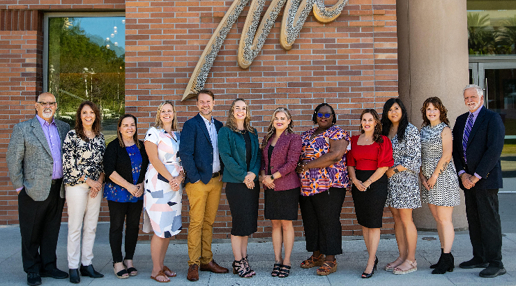 Jill Perez, Kari Adams, Audri Sandoval Gomez, and Shayne Brophy are standing next to each other in front of a screen with the title slide from their "Innovative Approaches for Redesigning Professional Development for Paraprofessionals in Inclusive Environments" presentation.