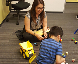 Dr. Carriere playing on the ground with a child