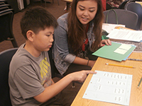 Teacher working with student at desk