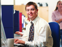 Person in dress shirt and tie sitting at a desk