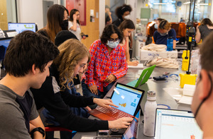 Students collaborate in a brightly lit engineering laboratory environment.