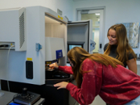 Two students looking through microscope