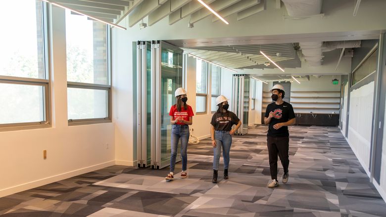 Students walking down bright hallway.