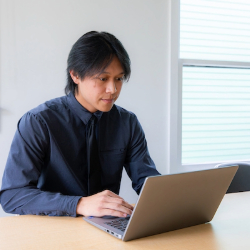 Man works on laptop at desk