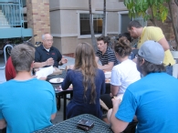 Students meeting with faculty member over pizza dinner.