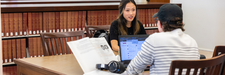 Two students sit and talk in Chapman University library