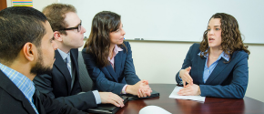 Woman explaining something to a group of three people