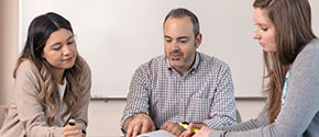 3 people at a table discussing something