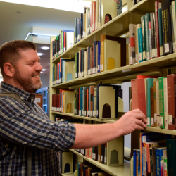 Man grabs book off of library shelf