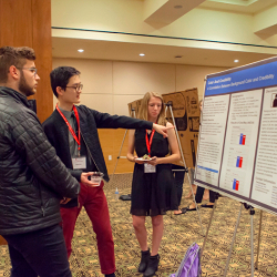 Students display their research poster at event