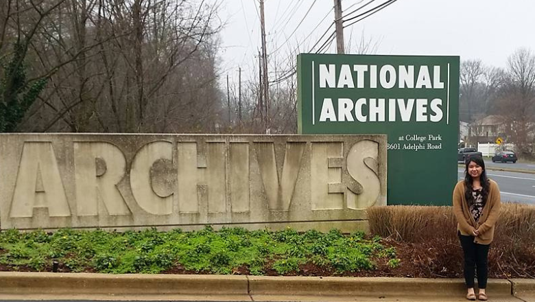 student in front of archive signage