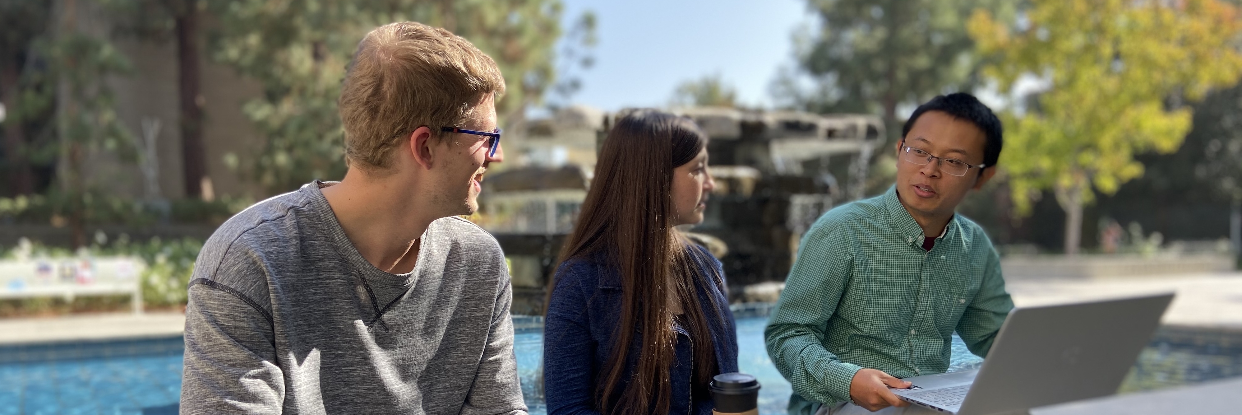 students sitting in front of fountain