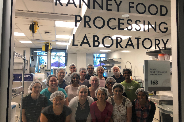 students behind lab glass window in hairnets 