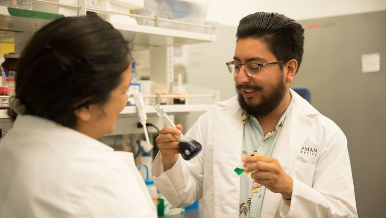 Two students talking to each other in a lab