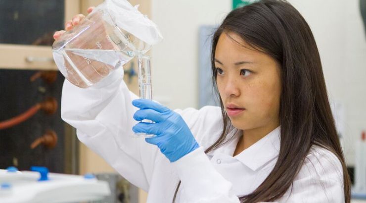 A student pouring liquid into a test tube