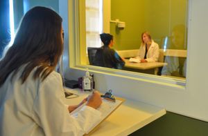 A student observes people in a psychology lab.