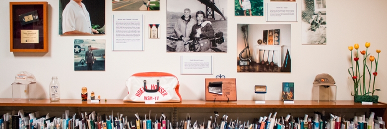 Wood shelf containing display of library books with decor on top of shelf