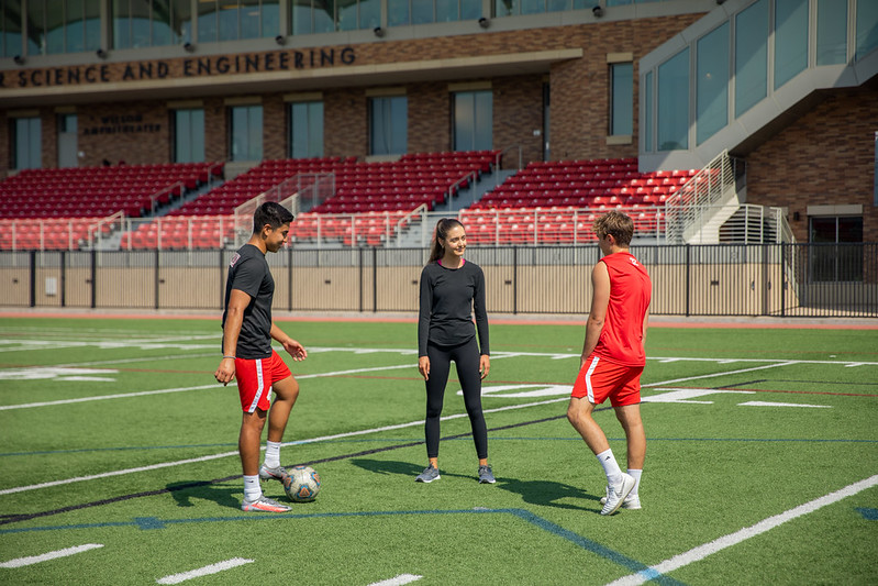 students on soccer field talking