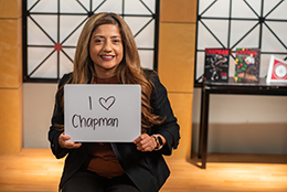 Woman holding 'I heart Chapman' sign