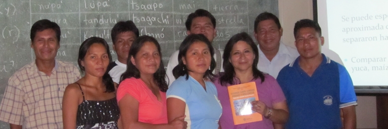 Group of people standing in front of a projection screen.